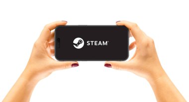 Cracow, Polonya - 26 Eylül 2022: iPhone 14 Pro bir kadının ellerinde, uygulama Buhar.