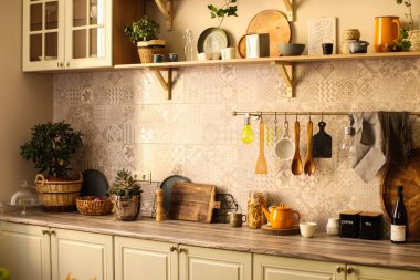 Kırsal tarzda parlak bir mutfak. İç mekan. Tabaklar, hafif dolaplar. Tahta kaşıklar ve tabaklar. Çiçekler..