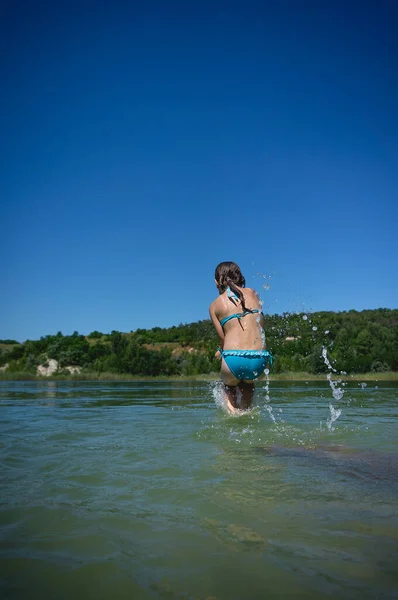 Uma Menina Fofa Maiô Salta Para Água Azul Lago Carreira — Fotografia de Stock