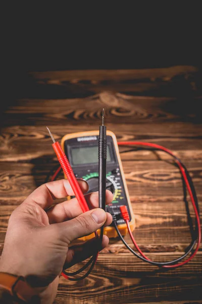 Multimeter Und Zwei Testleitungen Auf Einem Hölzernen Hintergrund Die Hand — Stockfoto