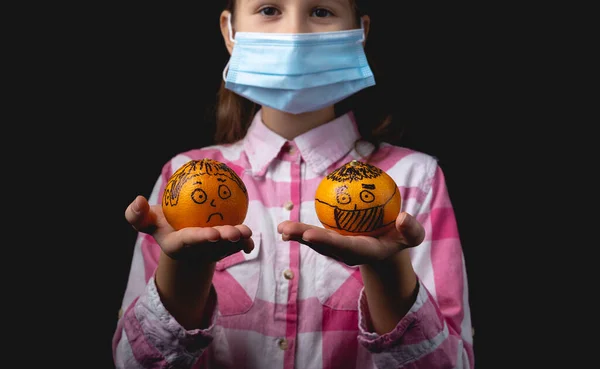 Una Niña Con Una Máscara Médica Sostiene Mano Dos Mandarinas —  Fotos de Stock