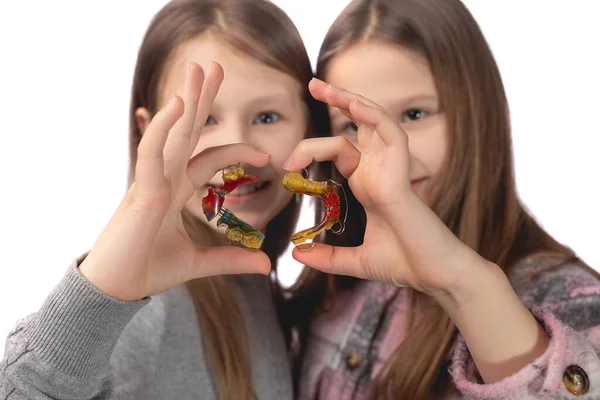 Dwie Słodkie Dziewczyny Figlarnie Pozować Urządzeń Ortodontycznych Ich Rękach Białym — Zdjęcie stockowe