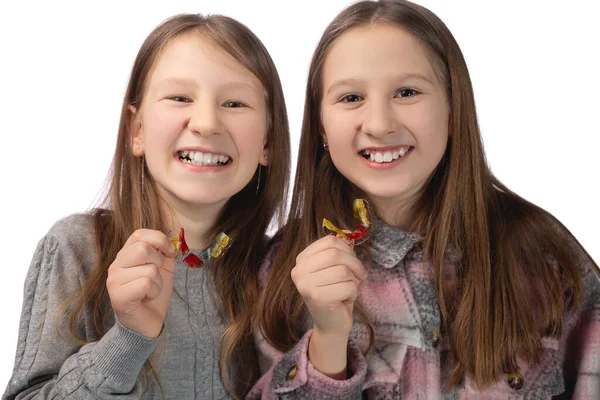 Дві Милі Дівчата Грайливо Позують Ортодонтичними Приладами Руках Білому Тлі — стокове фото