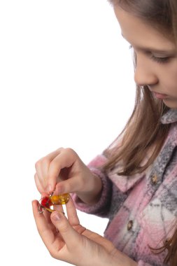 Çocuk elinde bir ortodontik cihaz ve ayarlamak için bir anahtar tutuyor. Çocuklukta diş hizalama kavramı. Beyaz arkaplanda stüdyo fotoğrafı.