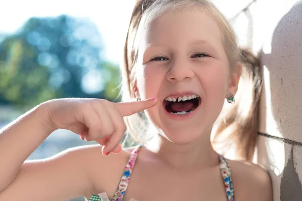 Dziewczynka Wskazuje Palcem Chwiejny Ząb Dziecka — Zdjęcie stockowe