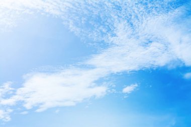 Mavi gökyüzü aydınlık bir yaz gününde beyaz bulutlarla donatılmıştır..