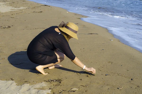 Дівчина пише на морському піску — стокове фото