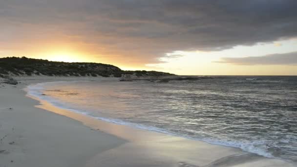 Ondas oceânicas lambendo a praia ao pôr do sol — Vídeo de Stock