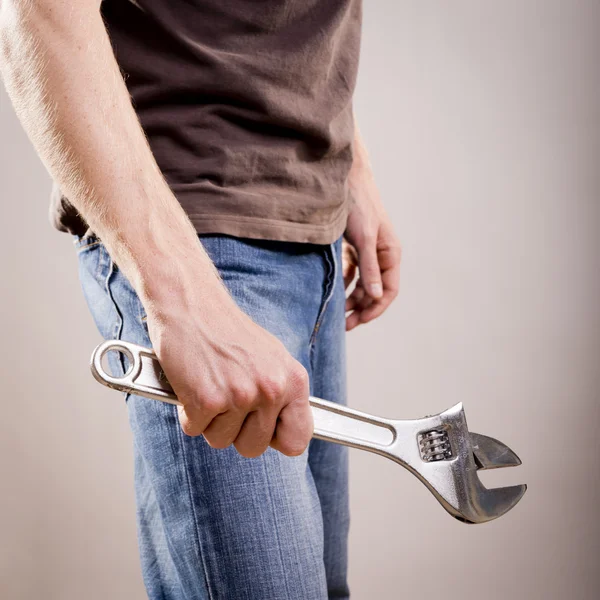 Homem segurando chave ajustável — Fotografia de Stock