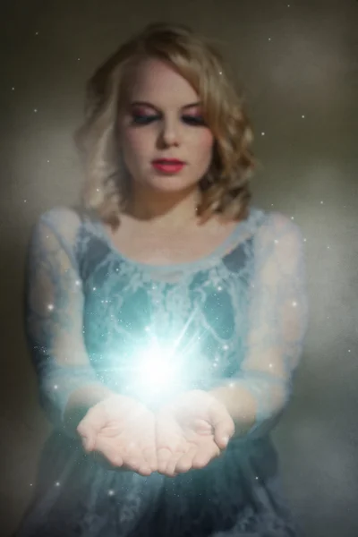 Beautiful woman holding magic lights in her hands — Stock Photo, Image