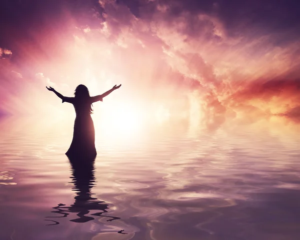 Woman lifting her hands up at sunset — Stock Photo, Image