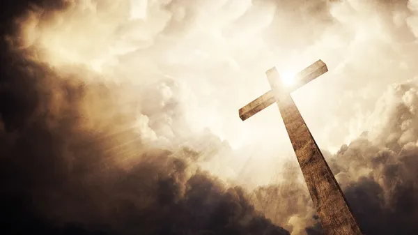 Una croce cristiana in legno con sole e nuvole luminose . Foto Stock Royalty Free