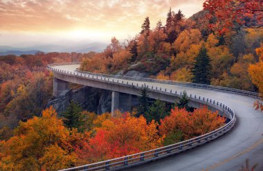 A curvy road through the mountains during fall season.