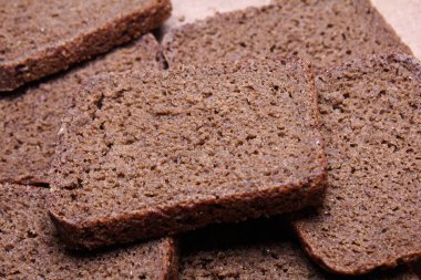 Tahta tezgahta dilimlenmiş siyah ekmek.