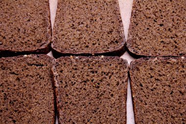 Tahta tezgahta dilimlenmiş siyah ekmek.