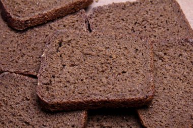 Tahta tezgahta dilimlenmiş siyah ekmek.