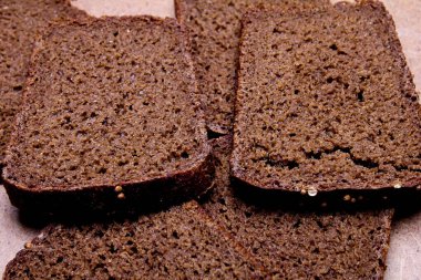 Tahta tezgahta dilimlenmiş siyah ekmek.