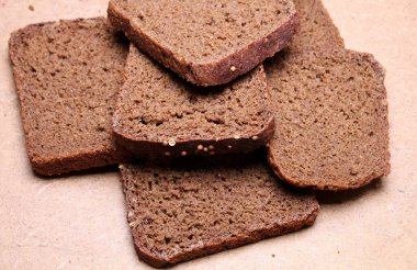 Tahta tezgahta dilimlenmiş siyah ekmek.