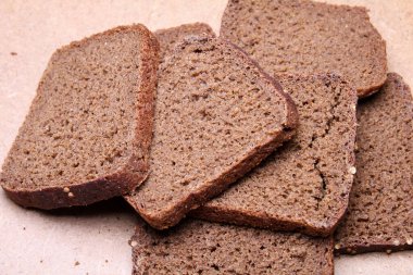 Tahta tezgahta dilimlenmiş siyah ekmek.