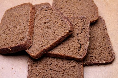 Tahta tezgahta dilimlenmiş siyah ekmek.