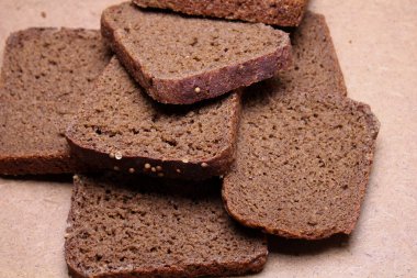 Tahta tezgahta dilimlenmiş siyah ekmek.