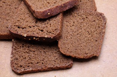 Tahta tezgahta dilimlenmiş siyah ekmek.