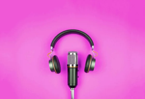 Directly above view of headphones and recording microphone on pink background with copy space — Stock Photo, Image