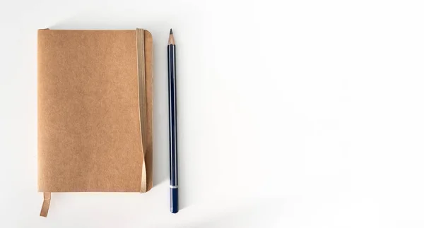 Small notebook and pencil on white desk —  Fotos de Stock