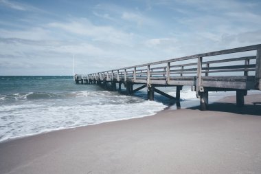 Kaba baltık denizinde ahşap iskele Karanlık ve rüzgarlı bir günde, Alman sahili