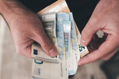 Avro banknotları tutan, para sayan bir adamın elleri.