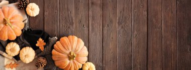 Koyu renk ahşap bir arka planda, sonbaharın sıcacık sınırında. Üst Manzara. Battaniye, balkabağı ve doğal dekor. Boşluğu kopyala.