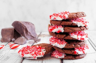 Bir yığın çikolatalı kurabiye. Beyaz ahşap arka planda yan görünüm.