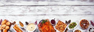 Klasik Noel hindi yemeği. Alt sınırın yukarısında beyaz ahşap bir afiş var. Hindi, patates, sos, meyveli pasta ve erikli puding..