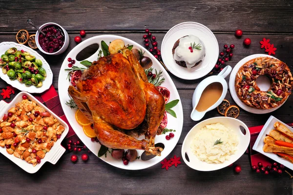 传统的圣诞火鸡晚餐 顶部的桌子场景在黑暗的木材背景 土耳其 土豆和面食 调味品 水果蛋糕和李子布丁 — 图库照片