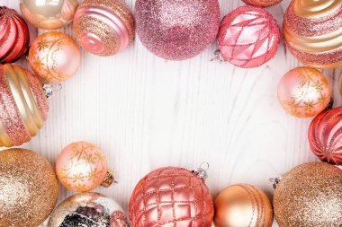 Pembe ve altın mücevherli Noel çerçevesi. Beyaz ahşap arka planda üst manzara. Boşluğu kopyala.