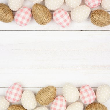 Paskalya yumurtası modern çiftlik evi tarzında yumurtaların çifte sınırı. Beyaz ahşap arka planda tepeden görüş. Boşluğu kopyala.