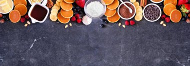 Kahvaltı ya da brunch, açık büfe büfesi. Koyu taştan bir arkaplanda manzaranın üstünde. Bir sürü malzemeyle mini krep..