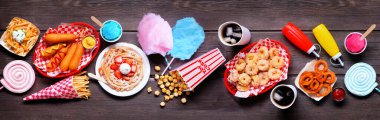 Karnaval temalı yemek masası sahnesi. Manzaranın üstünde. Yaz festivali konsepti. Sosisli sandviç, huni keki, pamuk şeker ve atıştırmalıklar..