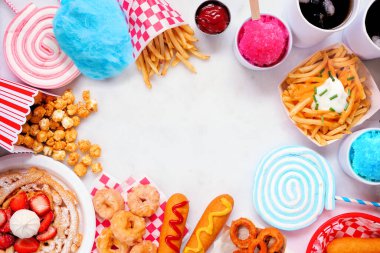 Beyaz mermer arka planda karnaval temalı yemek çerçevesi. Fotokopi alanı ile görüntünün üstünde. Yaz festivali konsepti. Sosisli sandviç, huni keki, pamuk şeker ve atıştırmalıklar..