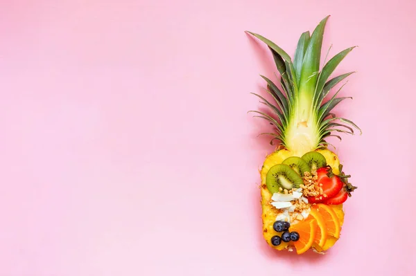 在菠萝中加入椰子 猕猴桃 浆果和橙子 制成健康的水果圆滑碗 在粉红的背景上的顶部视图 复制空间 — 图库照片