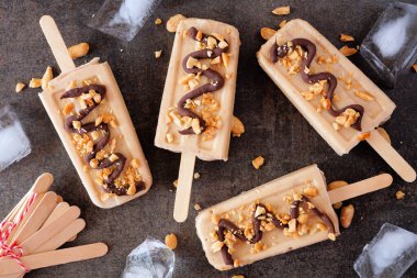 Fıstık ezmeli ve çikolatalı dondurma. Koyu renkli bir arkaplan üzerinde üst görünüm.