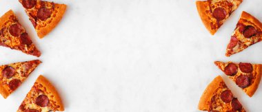 Pepperoni pizza slice double border. Overhead view on a white marble banner background. Copy space.