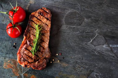 Delicious grilled steak. Above view on a dark slate background with copy space.