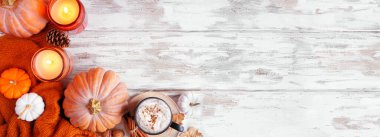 Balkabakları, yapraklar, süveter ve balkabağı baharatlı içeceklerle dolu sıcak sonbahar köşesi sınırı. Kırsal beyaz ahşap afiş arkaplanının üst görüntüsü. Boşluğu kopyala.