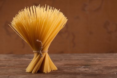 pişmemiş İtalyan kurutulmuş makarna dize ile bağlı.