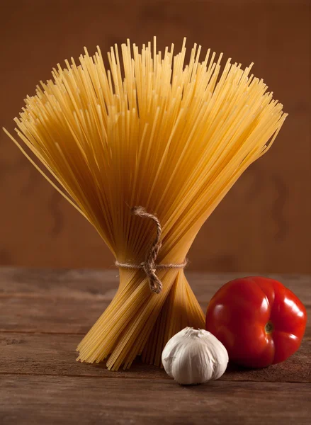 Okokt italienska torkade spagetti bundna med sträng. — Stockfoto