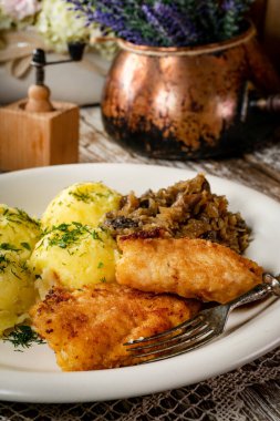 Kızarmış morina filetosu, haşlanmış patates ve mantarlı kızarmış lahana turşusu..