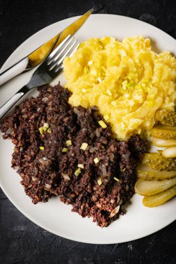 Kızarmış puding, patates püresi ve salatalık turşusu..