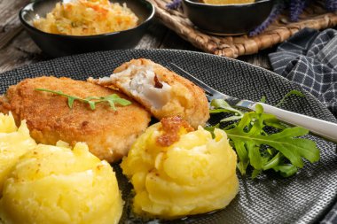 Haşlanmış patates ve sebze salatasıyla servis edilen kızarmış morina filetosu..