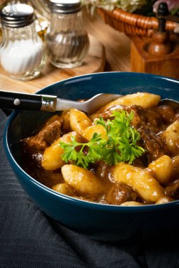 Soslu sığır eti yahnisi, patates köftesiyle servis edilir..